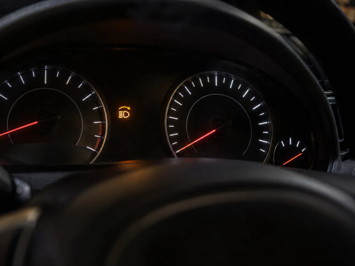 Instrument cluster showing the adaptive front lighting warning light next to the speedometer