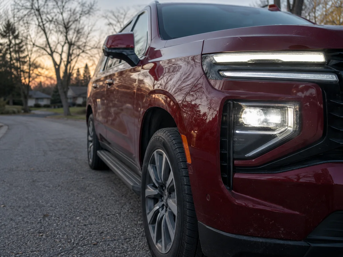 LED headlight on the front of a full-size Chevrolet SUV, seen from the side at dusk