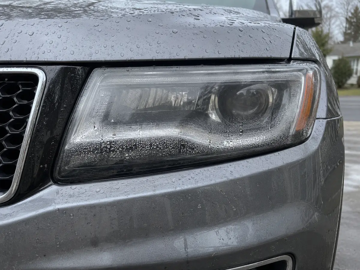 Droplets of condensation along the lens of a Jeep Grand Cherokee headlight