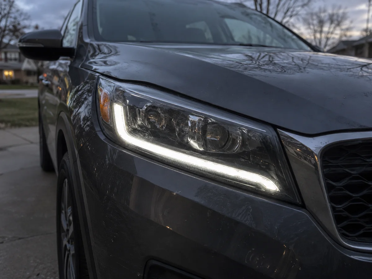 LED headlight of a Kia SUV with the daytime running light lit, seen from the front corner
